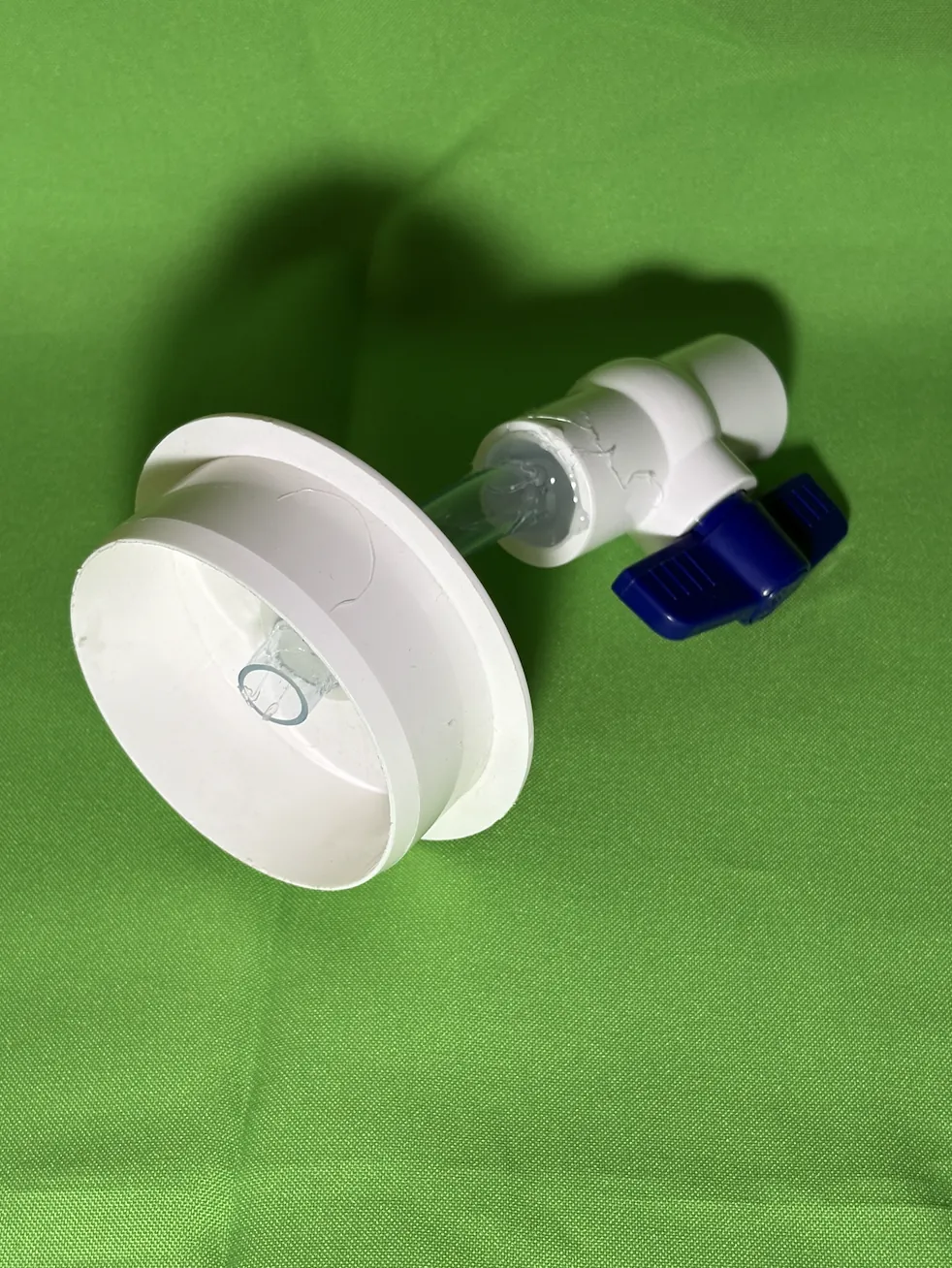 PVC end cap with clear hose passing through its centre into a ball valve