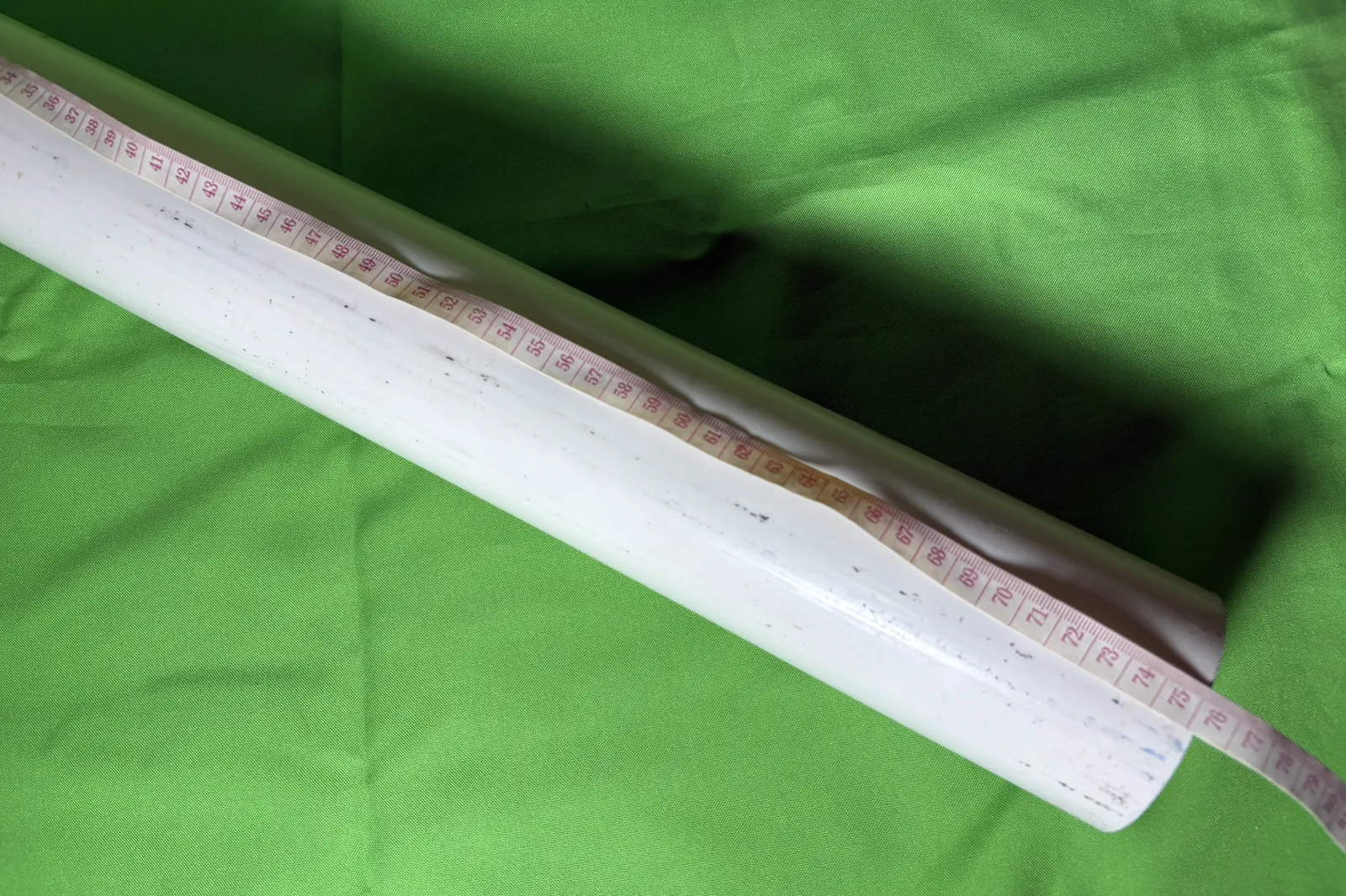 White PVC pipe with a tape measure along it reading 75 cm