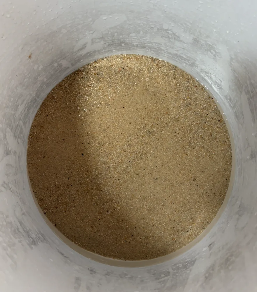 Tub of rinsed fine silica sand under clear water